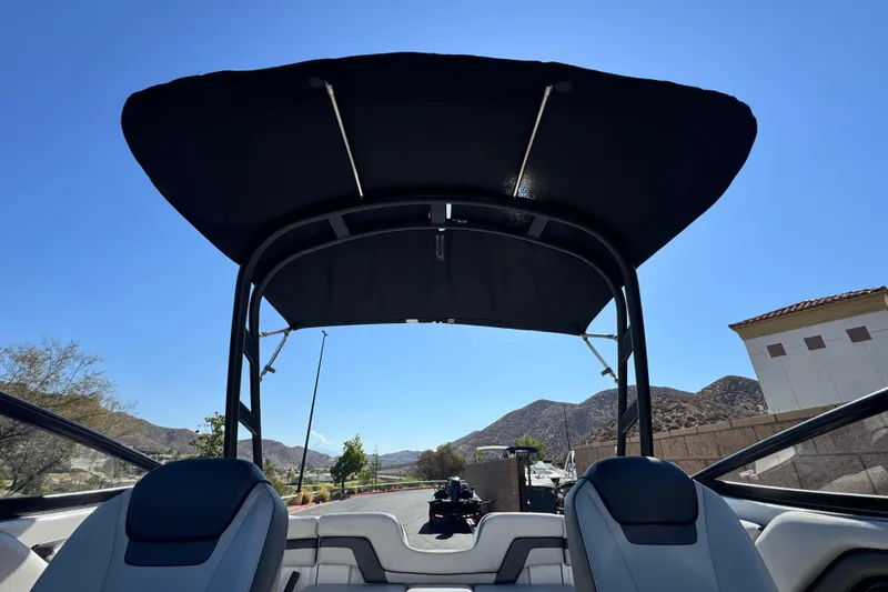 Slide: The Image of 2020 Yamaha Boats AR240 interior with canopy, mountain view in background. - 12