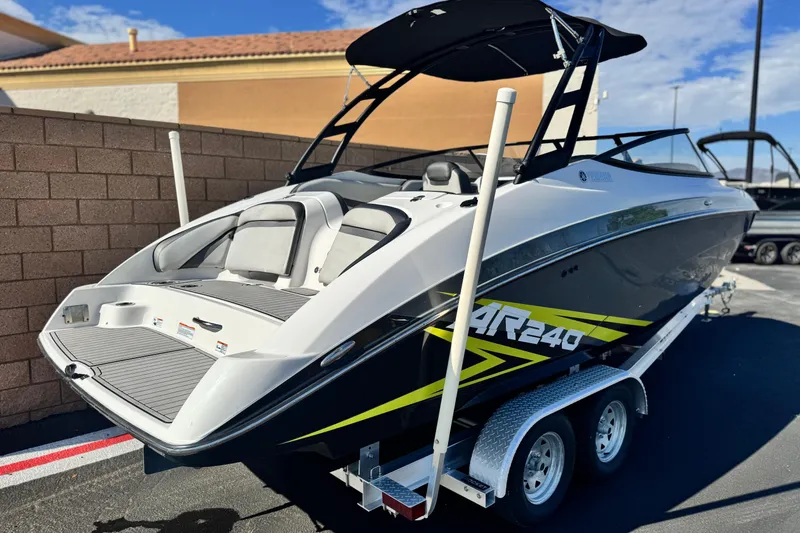 Slide: The Image of 2020 Yamaha Boats AR240 on trailer, sleek design, black and white with yellow accents. - 5