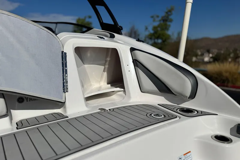 Slide: The Image of 2020 Yamaha Boats AR240 showing open storage compartment and sleek deck design. - 9