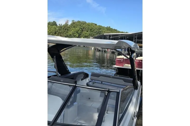 Slide: The Image of 2021 Cobalt A29 boat docked on a serene lake with lush greenery. - 3