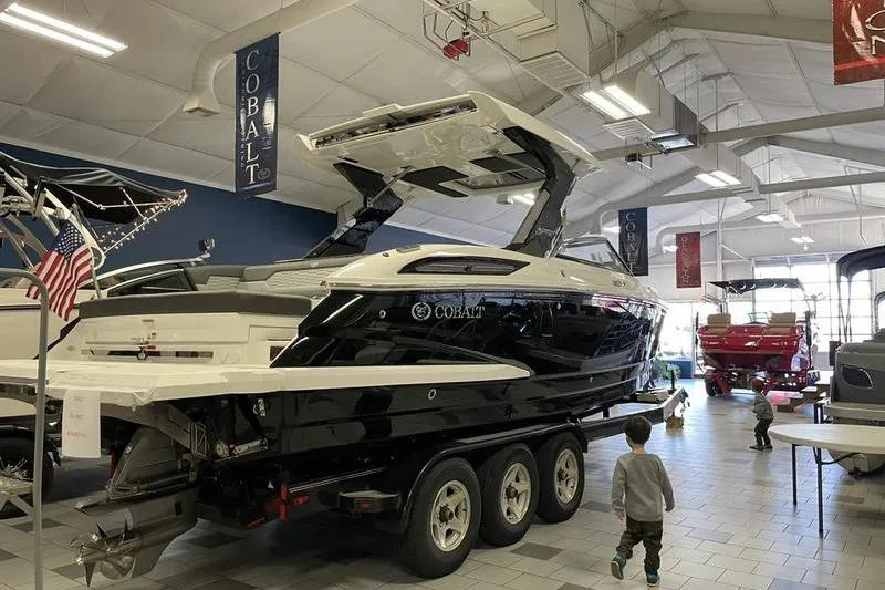 Slide: The Image of 2021 Cobalt A29 boat displayed in a showroom with a child nearby. - 6