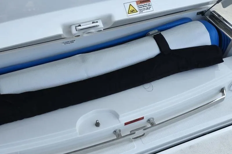 Slide: The Image of Storage compartment in a 2021 Cobalt A29 boat, featuring rolled-up mats. - 8