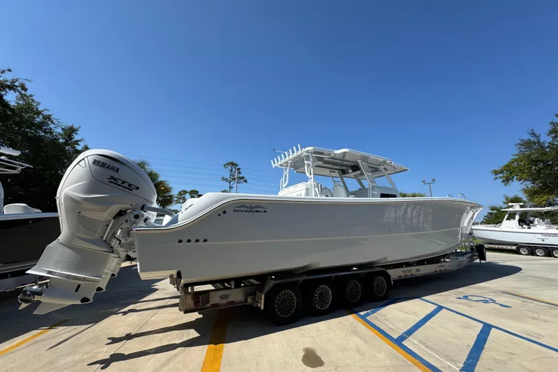 Slide: The Image of 2026 Invincible 46 Catamaran on trailer, featuring Yamaha outboard engines, under clear blue sky. - 12