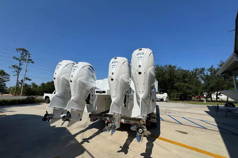 Slide: The Image of 2026 Invincible 46 Catamaran with quad 450 V8 outboard engines, parked outdoors. - 14