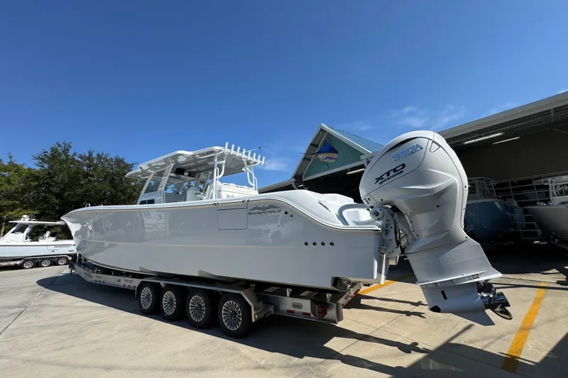 Slide: The Image of 2026 Invincible 46 Catamaran with Yamaha outboard engines on a trailer, under clear blue sky. - 18
