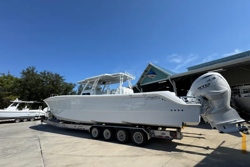 Slide: The Image of 2026 Invincible 46 Catamaran on trailer, parked outdoors under clear blue sky. - 19