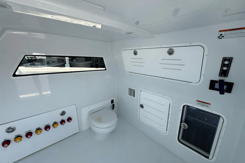 Slide: The Image of Interior of 2026 Invincible 46 Catamaran featuring control panel and compact toilet. - 27