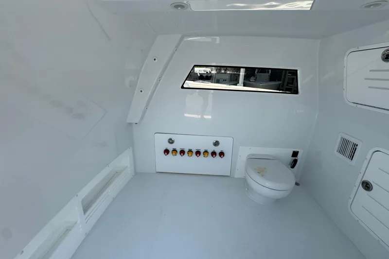 Slide: The Image of Interior of 2026 Invincible 46 Catamaran featuring a modern marine toilet and control panel. - 28