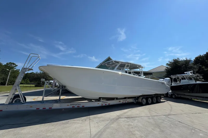 Slide: The Image of 2026 Invincible 46 Catamaran on trailer under clear blue sky. - 3