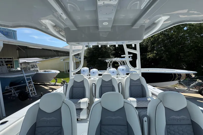 Slide: The Image of 2026 Invincible 46 Catamaran with luxurious seating, docked at a marina under clear skies. - 32