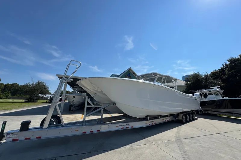 Slide: The Image of 2026 Invincible 46 Catamaran on trailer under clear blue sky. - 4