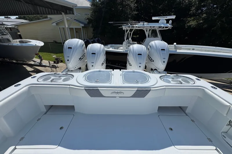 Slide: The Image of 2026 Invincible 46 Catamaran with quad outboard engines, docked in a marina. - 46