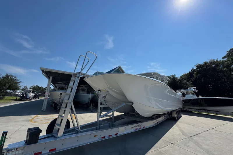 Slide: The Image of 2026 Invincible 46 Catamaran on trailer under clear blue sky. - 5
