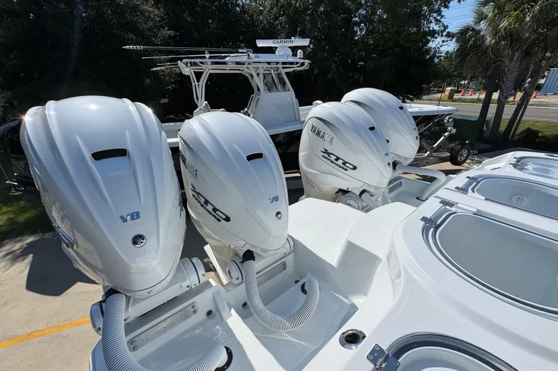 Slide: The Image of Four Yamaha outboard engines on a 2026 Invincible 46 Catamaran, parked outdoors. - 51