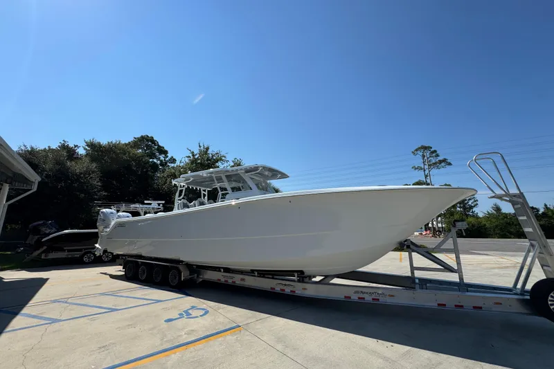 Slide: The Image of 2026 Invincible 46 Catamaran on trailer under clear blue sky. - 9