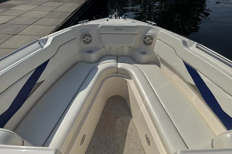 Slide: The Image of 2007 Rinker 282 boat interior with white seating and blue accents. - 14