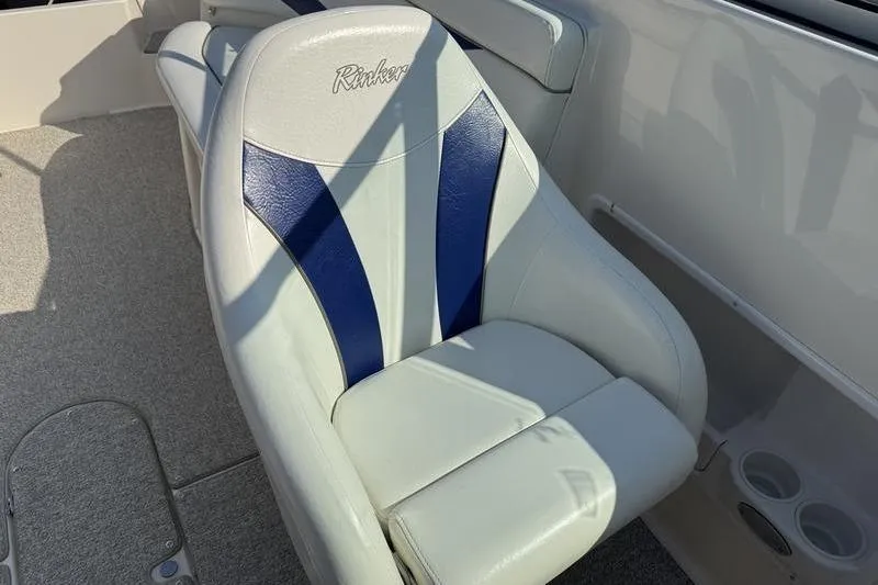 Slide: The Image of 2007 Rinker 282 boat seat with blue and white upholstery, featuring cup holders. - 16