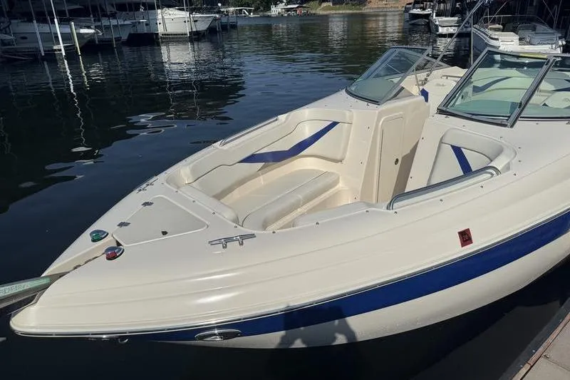 Slide: The Image of 2007 Rinker 282 boat docked on calm water, featuring spacious seating and sleek design. - 4