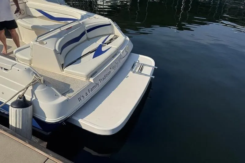 Slide: The Image of 2007 Rinker 282 boat docked, featuring rear seating and swim platform. - 6