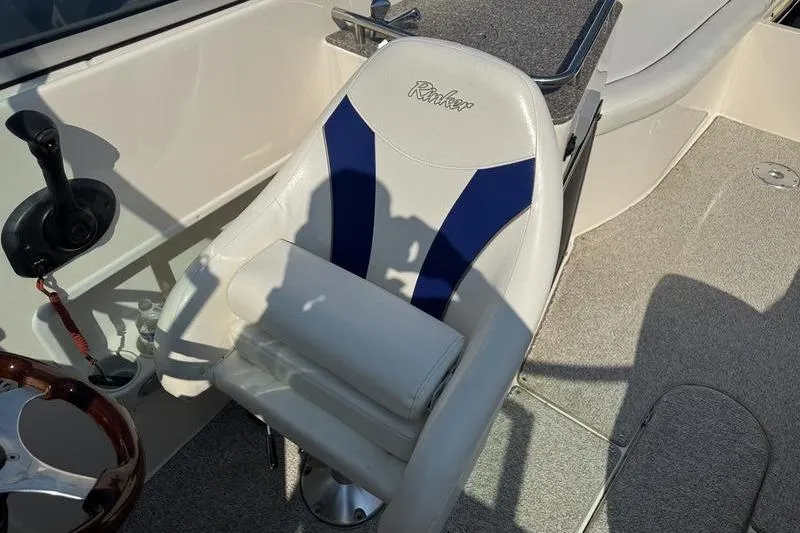 Slide: The Image of Captain's seat on a 2007 Rinker 282 boat, featuring blue and white upholstery. - 9