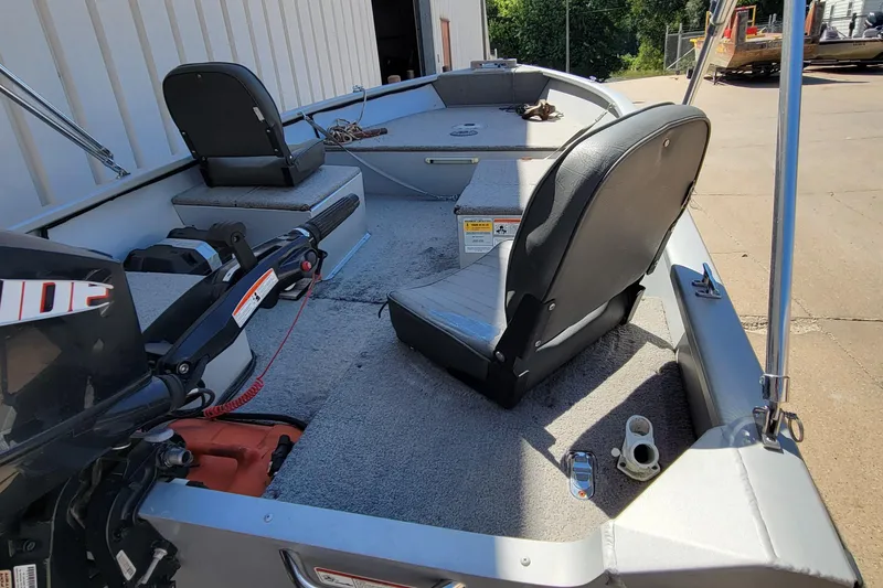 Slide: The Image of 2010 Tracker Guide V 15 Laker boat interior with seating and motor. - 12