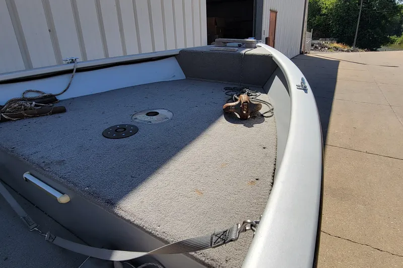 Slide: The Image of 2010 Tracker Guide V 15 Laker boat deck with ropes and anchor, outdoors. - 14