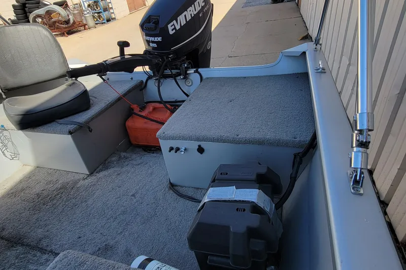 Slide: The Image of 2010 Tracker Guide V 15 Laker boat interior with Evinrude motor and seating. - 15