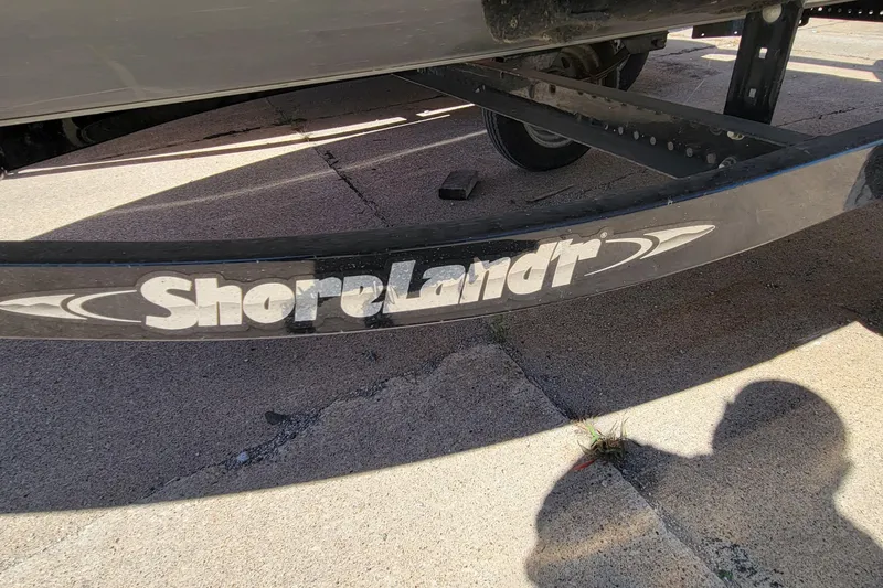 Slide: The Image of ShoreLand'r trailer for 2010 Tracker Guide V 15 Laker boat on concrete surface. - 9
