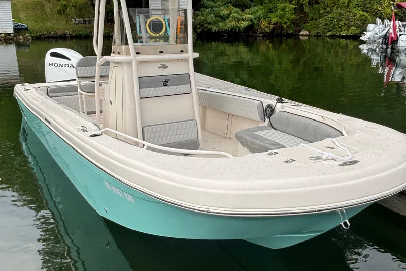 Slide: The Image of 2025 Carolina Skiff 23 Ultra Elite boat docked on calm water. - 16