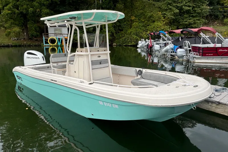 Slide: The Image of 2025 Carolina Skiff 23 Ultra Elite boat docked on calm water. - 17