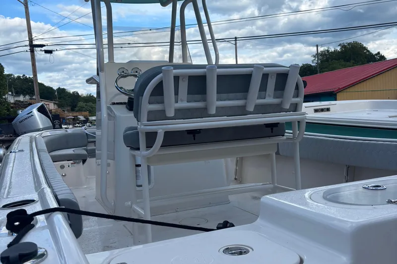 Slide: The Image of 2025 Carolina Skiff 23 Ultra Elite boat interior with seating and console, under cloudy sky. - 5
