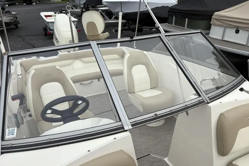 Slide: The Image of 2017 Stingray 191DC O/B boat interior with beige seating and steering wheel. - 11