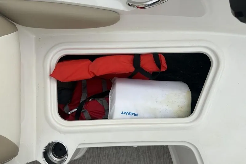 Slide: The Image of 2017 Stingray 191DC O/B boat storage with life jackets and a white fender. - 12