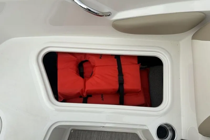 Slide: The Image of Storage compartment with life jackets in a 2017 Stingray 191DC O/B boat. - 14