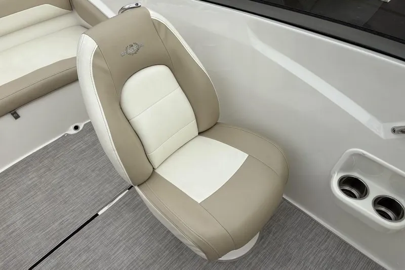 Slide: The Image of 2017 Stingray 191DC O/B boat seat with beige and white upholstery, featuring cup holders. - 16