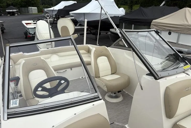 Slide: The Image of 2017 Stingray 191DC O/B boat interior with beige seating and steering wheel. - 19