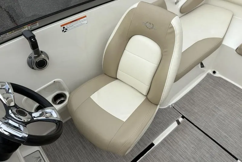Slide: The Image of 2017 Stingray 191DC O/B boat interior with beige and white seating, steering wheel, and controls. - 26