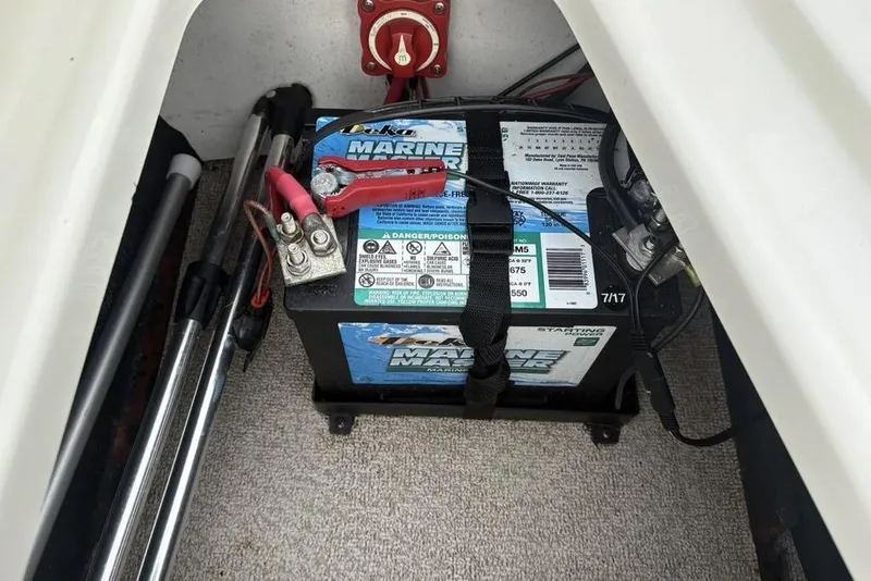 Slide: The Image of 2017 Stingray 191DC O/B marine battery compartment with secured battery and wiring. - 30