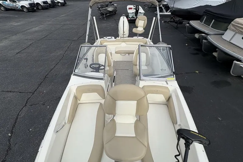 Slide: The Image of 2017 Stingray 191DC O/B boat with beige seating, parked in a marina. - 32