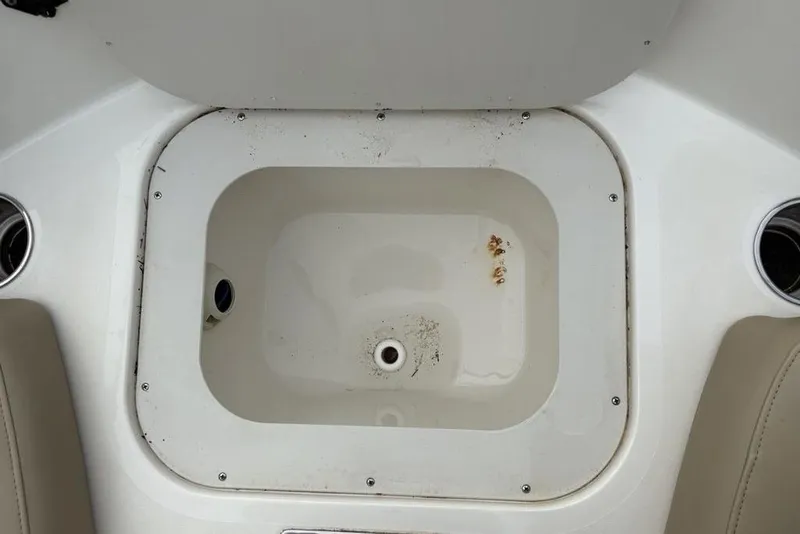Slide: The Image of 2017 Stingray 191DC O/B boat storage compartment with cup holders and drain. - 6