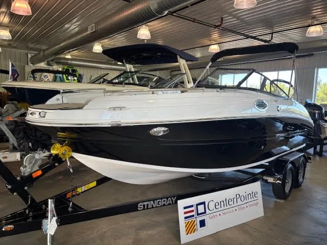 The Image of 2026 Stingray 211DC boat displayed indoors on a trailer at CenterPointe dealership. - 0