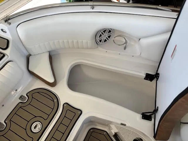 Slide: The Image of 2026 Stingray 211DC boat interior with white seating and storage compartment. - 19