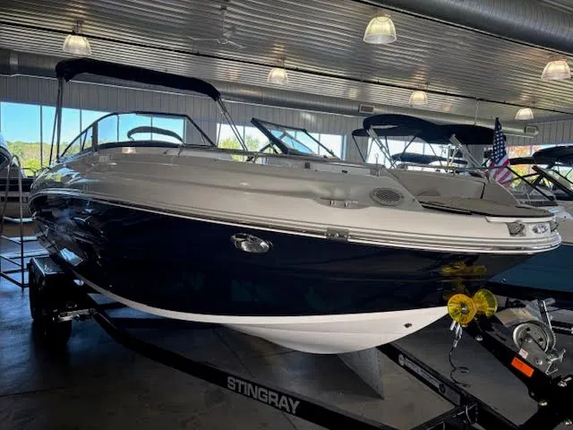 Slide: The Image of 2026 Stingray 211DC boat displayed indoors with sleek design and modern features. - 2