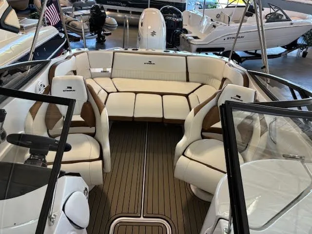 Slide: The Image of 2026 Stingray 211DC boat interior with white seating and wood flooring. - 25