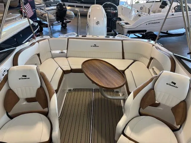Slide: The Image of 2026 Stingray 211DC boat interior with elegant seating and wooden table. - 27