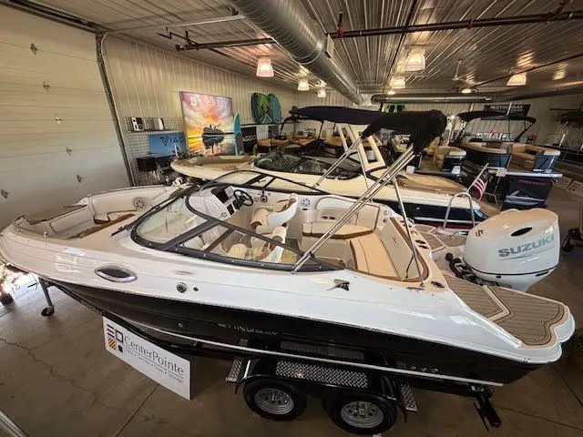 Slide: The Image of 2026 Stingray 211DC boat displayed indoors with Suzuki outboard motor. - 4