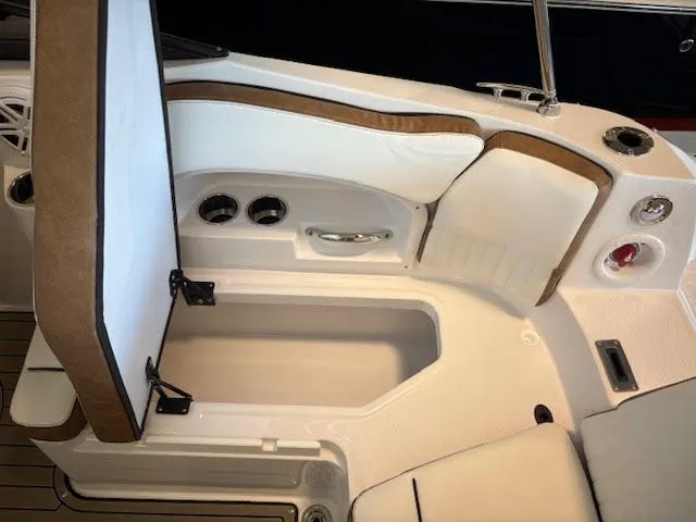 Slide: The Image of 2026 Stingray 211DC boat interior with open storage compartment and cushioned seating. - 9