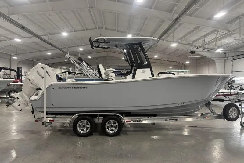 The Image of 2026 Sportsman Open 232 Center Console boat on trailer in indoor showroom. - 2