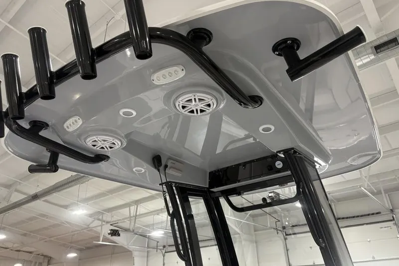 Slide: The Image of 2026 Sportsman Open 232 Center Console T-top with rod holders and speakers in a showroom. - 22