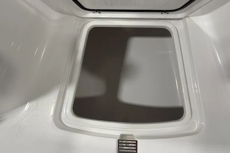 Slide: The Image of 2026 Sportsman Open 232 Center Console storage compartment, white interior, open hatch view. - 5